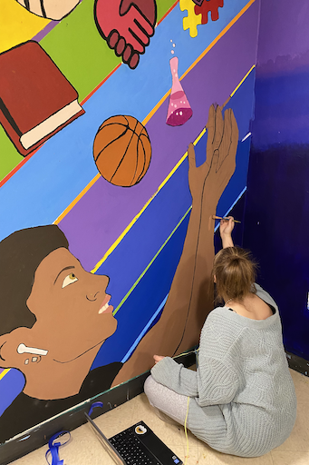 Student painting a mural